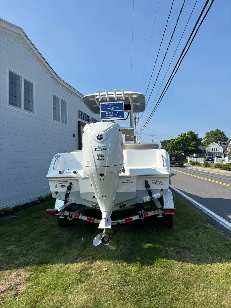 Slide: The Image of 2026 Sea Hunt Ultra 235 SE boat parked on grass beside a road. - 2