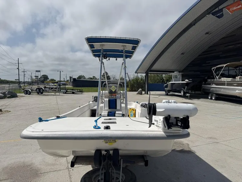 Slide: The Image of 2010 Carolina Skiff DLV 178 boat parked near a modern building. - 2