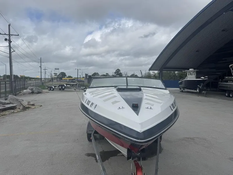 Slide: The Image of 1990 Rinker 206 Captiva Cuddy boat on trailer, parked outdoors under cloudy sky. - 2