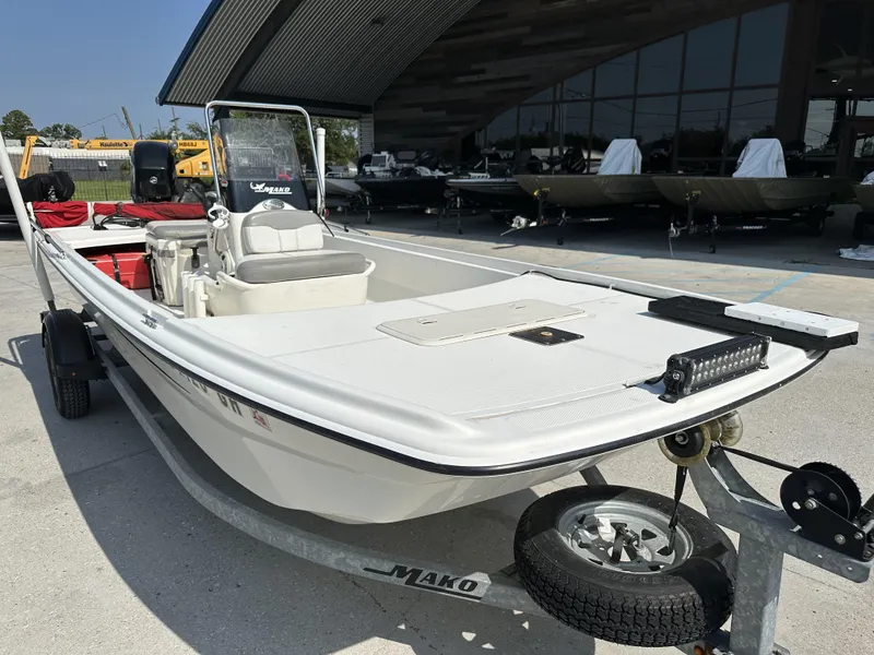 Slide: The Image of 2018 Mako 17 Pro Skiff boat on trailer, parked outdoors near a building. - 5
