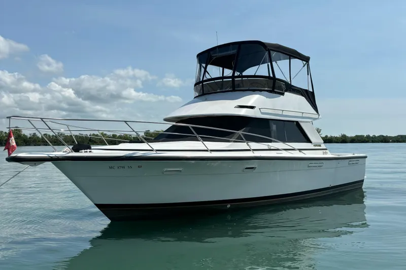 Slide: The Image of 1989 Phoenix 33 Sportfish boat on calm water under a clear sky. - 0