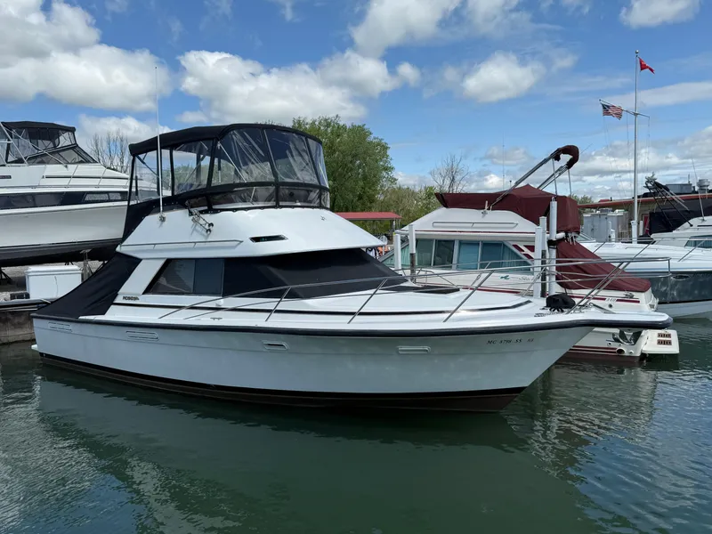 Slide: The Image of 1989 Phoenix 33 SFX boat docked in a marina under a partly cloudy sky. - 1