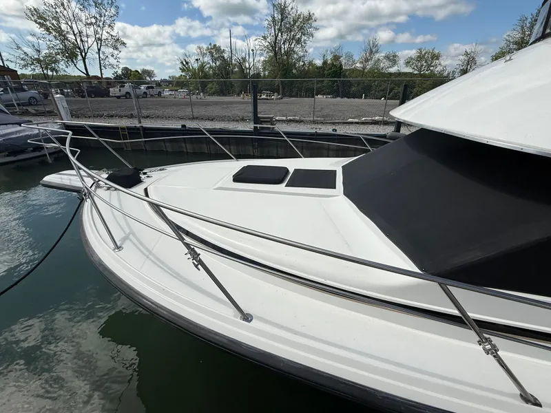 Slide: The Image of 1989 Phoenix 33 SFX boat docked, featuring sleek white design and stainless steel railings. - 10