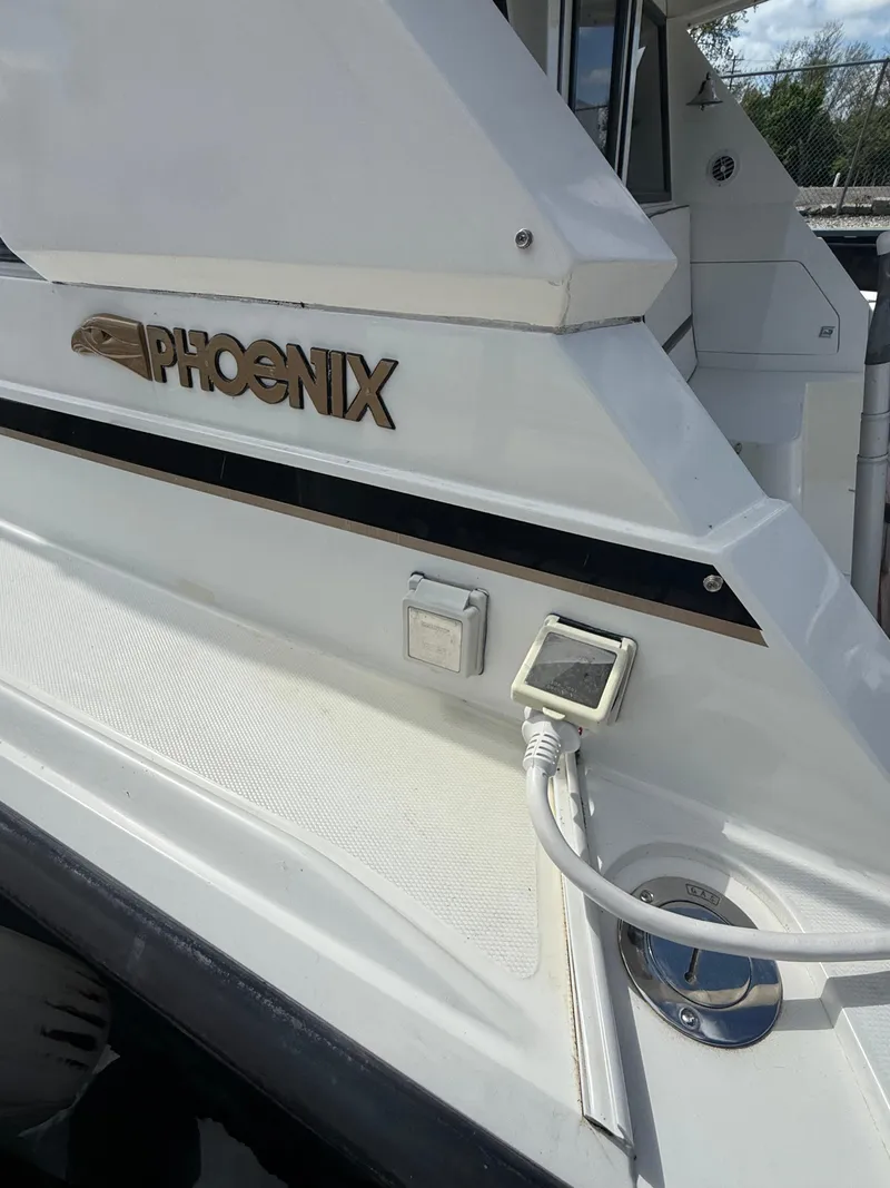 Slide: The Image of 1989 Phoenix 33 SFX boat with white exterior and visible power connection. - 11