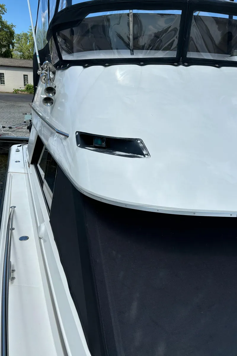 Slide: The Image of 1989 Phoenix 33 Sportfish boat, close-up of sleek white exterior and windows. - 12