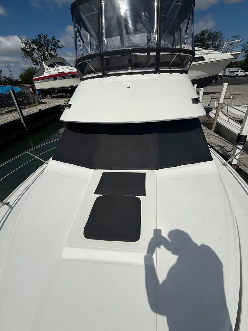 Slide: The Image of 1989 Phoenix 33 SFX boat with flybridge, docked at marina under clear sky. - 13