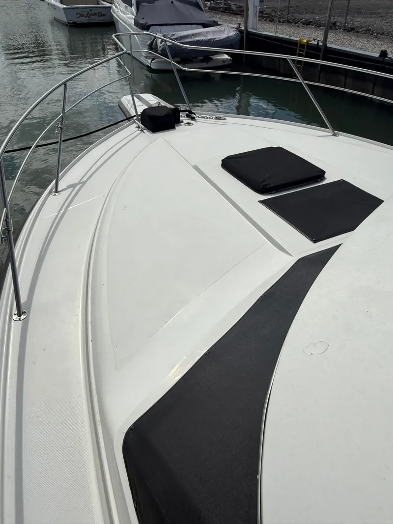 Slide: The Image of 1989 Phoenix 33 SFX boat deck with cushions, docked in a marina. - 15