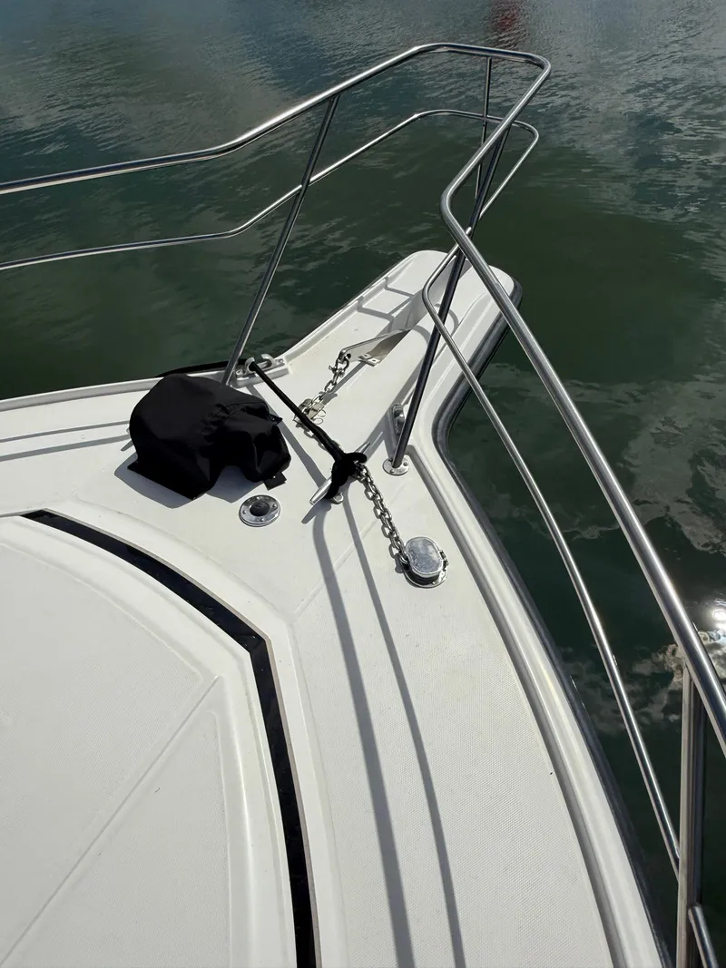 Slide: The Image of 1989 Phoenix 33 SFX boat bow with anchor and railing on calm water. - 17