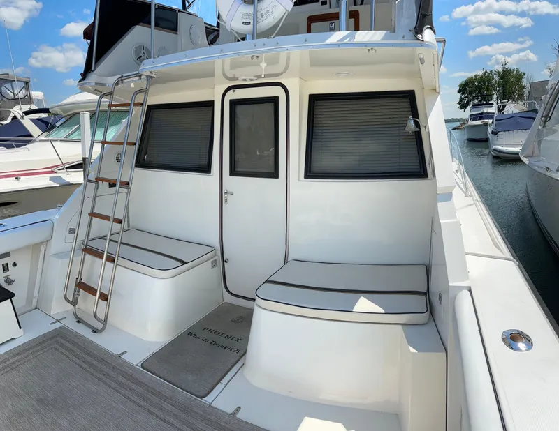 Slide: The Image of 1989 Phoenix 33 Sportfish boat deck with seating, ladder, and marina view. - 19