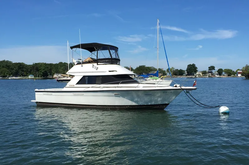 Slide: The Image of 1989 Phoenix 33 Sportfish boat on calm water, clear sky background. - 2