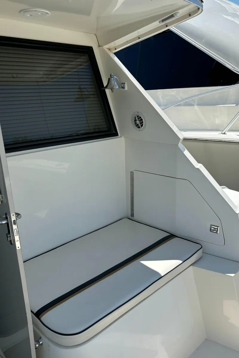 Slide: The Image of 1989 Phoenix 33 Sportfish boat interior with cushioned seating and window. - 24