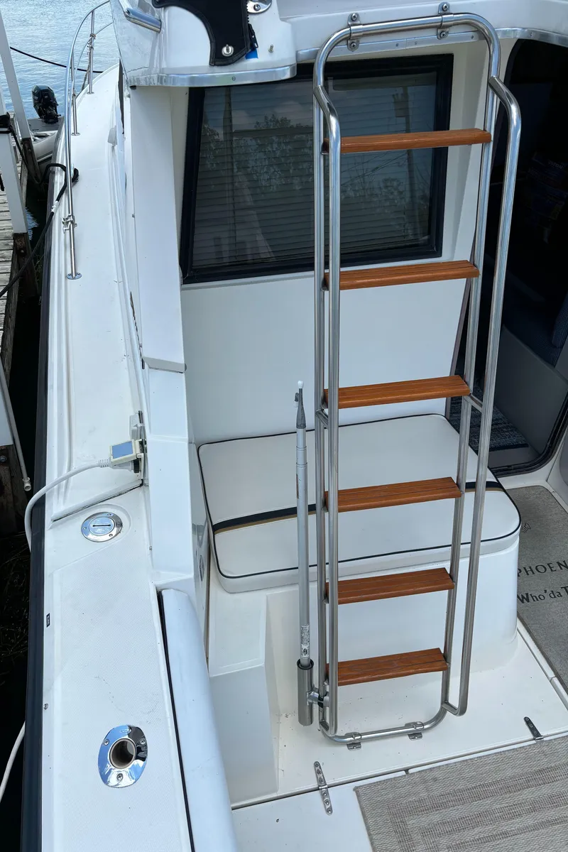 Slide: The Image of 1989 Phoenix 33 Sportfish boat with ladder and seating area on deck. - 28
