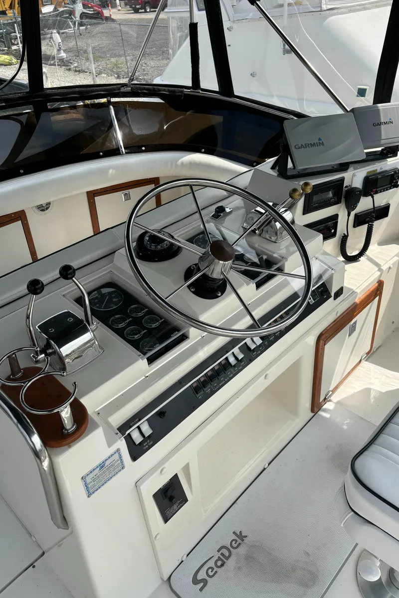 Slide: The Image of 1989 Phoenix 33 Sportfish boat helm with steering wheel and navigation equipment. - 29