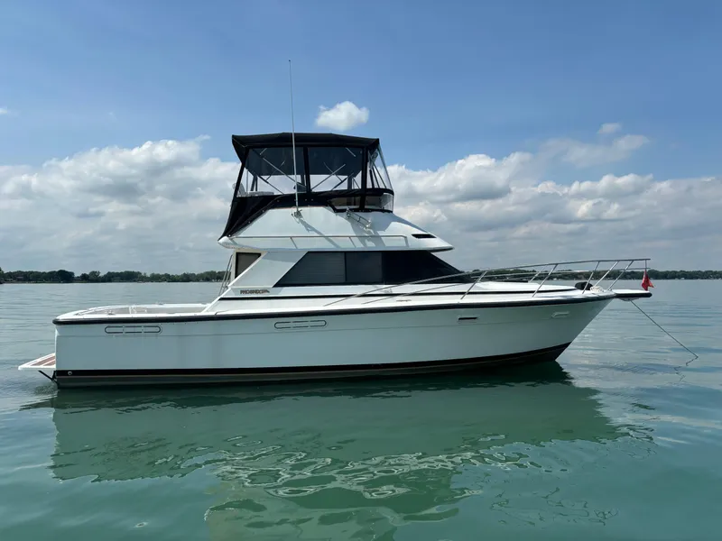 Slide: The Image of 1989 Phoenix 33 Sportfish boat on calm water under a partly cloudy sky. - 3
