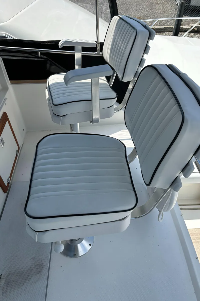 Slide: The Image of 1989 Phoenix 33 Sportfish boat with white cushioned seats and black trim. - 30