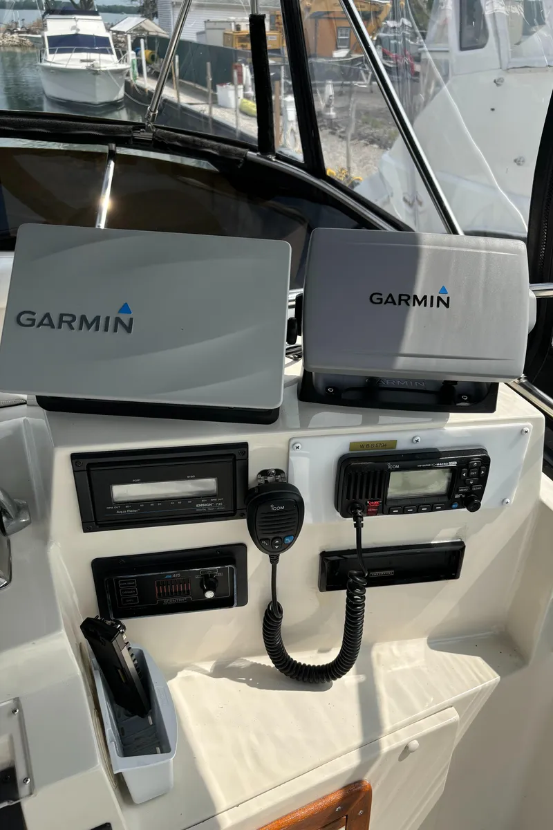 Slide: The Image of Phoenix 33 Sportfish 1989 boat dashboard with Garmin navigation systems and communication equipment. - 33