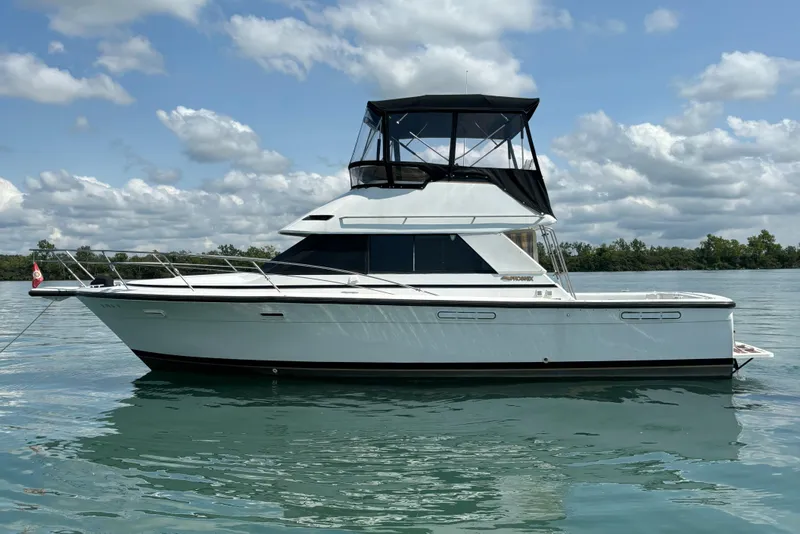 Slide: The Image of 1989 Phoenix 33 Sportfish boat on calm water under a cloudy sky. - 4
