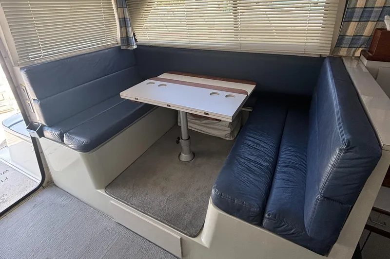 Slide: The Image of 1989 Phoenix 33 Sportfish interior with blue cushioned seating and a central table. - 40