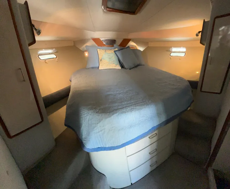 Slide: The Image of Cozy cabin interior of 1989 Phoenix 33 Sportfish with bed and storage drawers. - 48