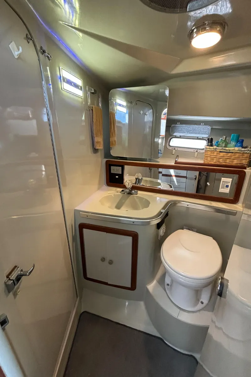 Slide: The Image of 1989 Phoenix 33 Sportfish boat bathroom with sink, toilet, and mirror. - 51