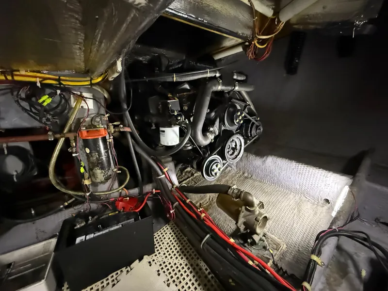 Slide: The Image of Engine room of a 1989 Phoenix 33 Sportfish boat, showcasing mechanical components and wiring. - 55