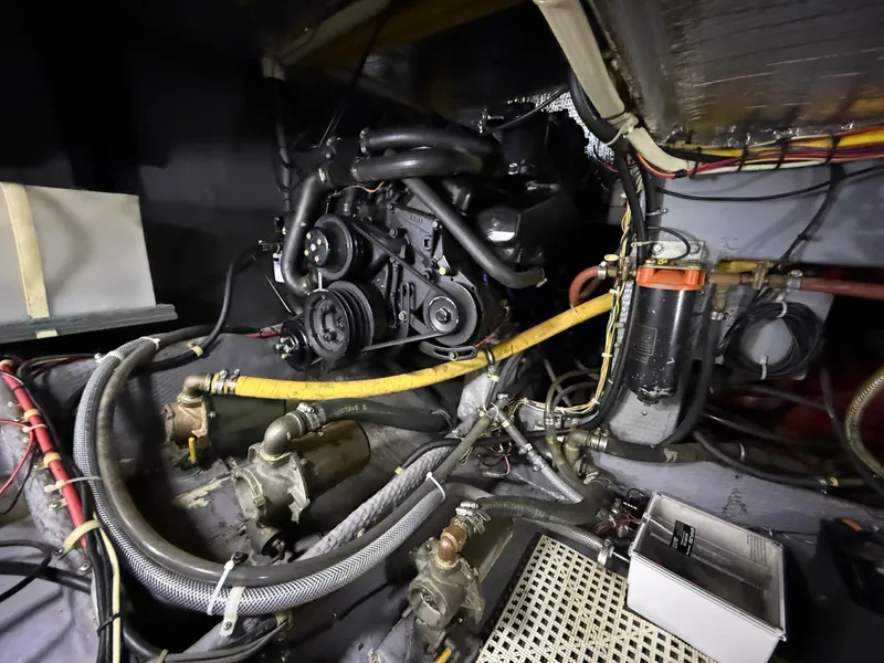 Slide: The Image of Engine room of a 1989 Phoenix 33 Sportfish boat, showcasing mechanical components and wiring. - 56