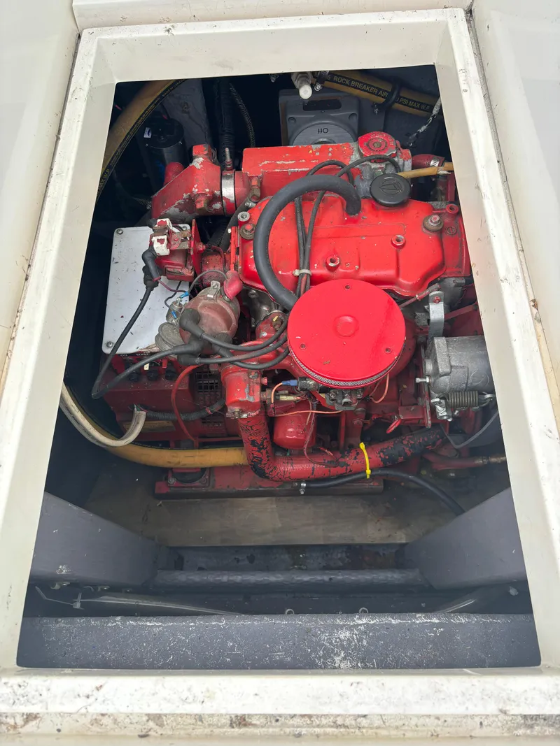 Slide: The Image of Engine compartment of a 1989 Phoenix 33 Sportfish boat, featuring a red engine. - 57