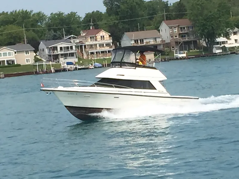 Slide: The Image of 1989 Phoenix 33 Sportfish cruising on a lake near waterfront homes. - 58