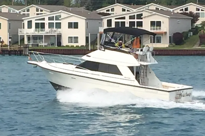 Slide: The Image of 1989 Phoenix 33 Sportfish cruising on water near waterfront homes. - 59