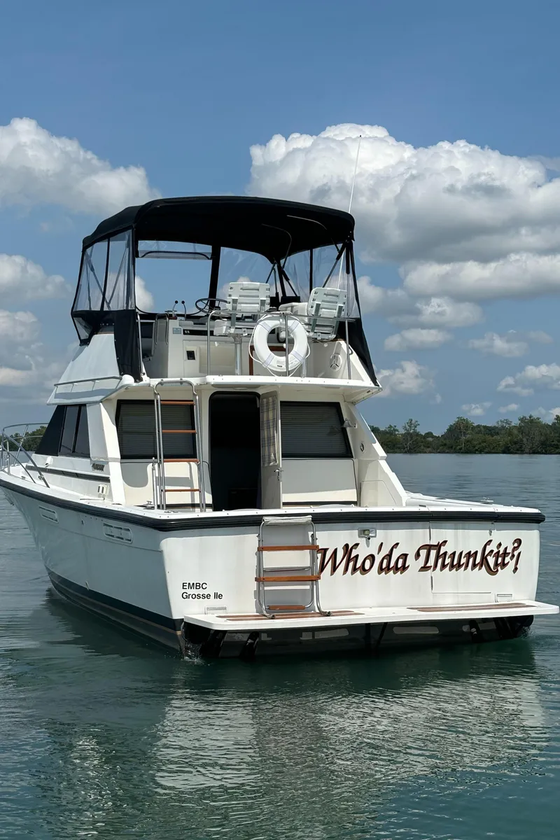 Slide: The Image of 1989 Phoenix 33 Sportfish boat on water, clear sky, rear view. - 6