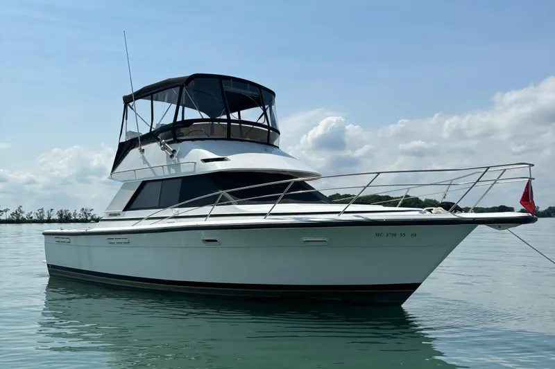 Slide: The Image of 1989 Phoenix 33 Sportfish boat on calm water under a clear sky. - 7