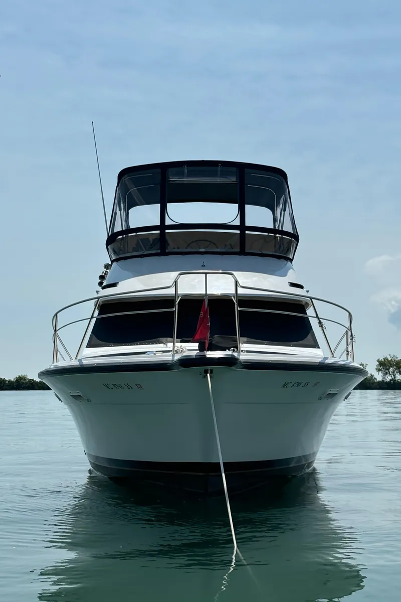 Slide: The Image of 1989 Phoenix 33 Sportfish boat on calm water, front view. - 8