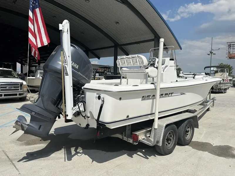 Slide: The Image of 2012 Sea Hunt BX 22 Pro boat on trailer, Yamaha motor, American flag in background. - 4