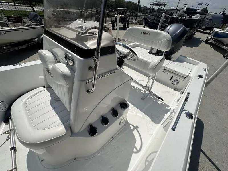 Slide: The Image of 2012 Sea Hunt BX 22 Pro boat interior with white seating and steering console. - 9
