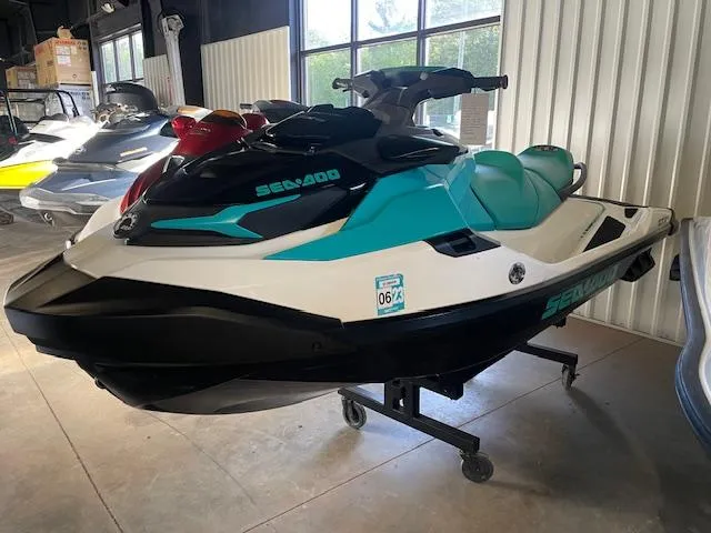 Slide: The Image of 2021 Sea-Doo GTX Pro jet ski in showroom, teal and black design. - 3