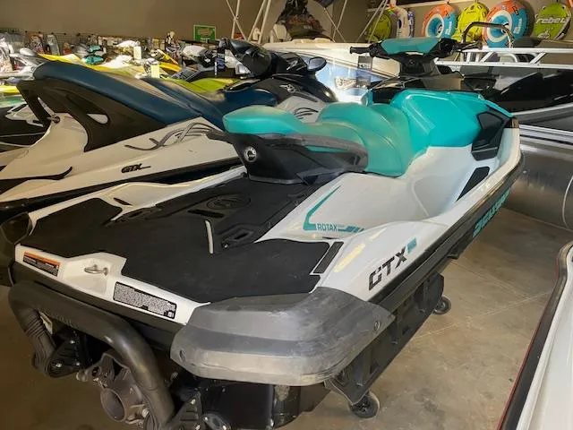 Slide: The Image of 2021 Sea-Doo GTX Pro jet ski in showroom, featuring sleek design and turquoise accents. - 4