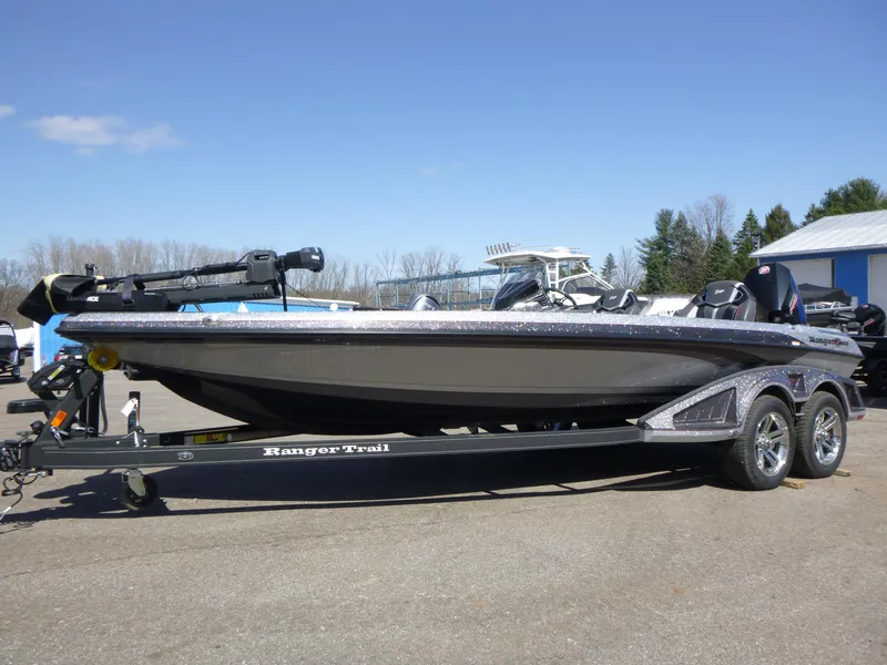 Slide: The Image of 2024 Ranger Z521R fishing boat on trailer, parked outdoors under clear blue sky. - 4