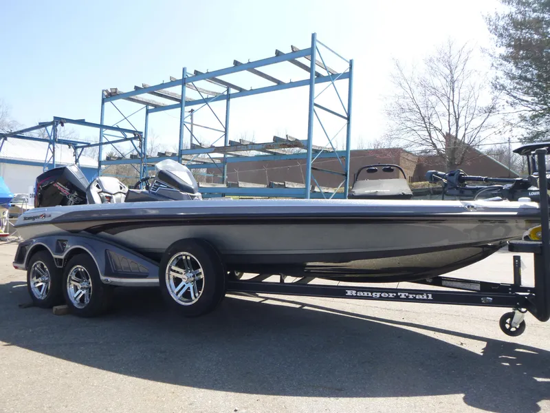 Slide: The Image of 2024 Ranger Z521R boat on trailer, parked outdoors, with metal racks in the background. - 7