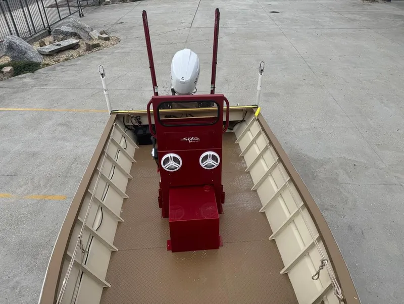 Slide: The Image of 2023 Custom Alumafab 20 CC boat with red console and dual speakers, parked on concrete. - 8