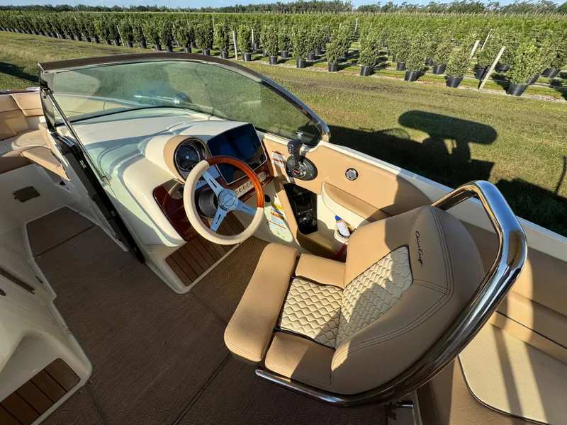 Slide: The Image of 2022 Chris-Craft Launch 25 GT boat interior with luxurious seating and steering wheel. - 14