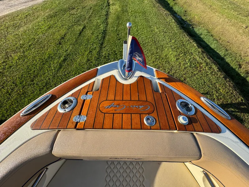 Slide: The Image of 2022 Chris-Craft Launch 25 GT boat with teak deck and flag, viewed from above. - 19