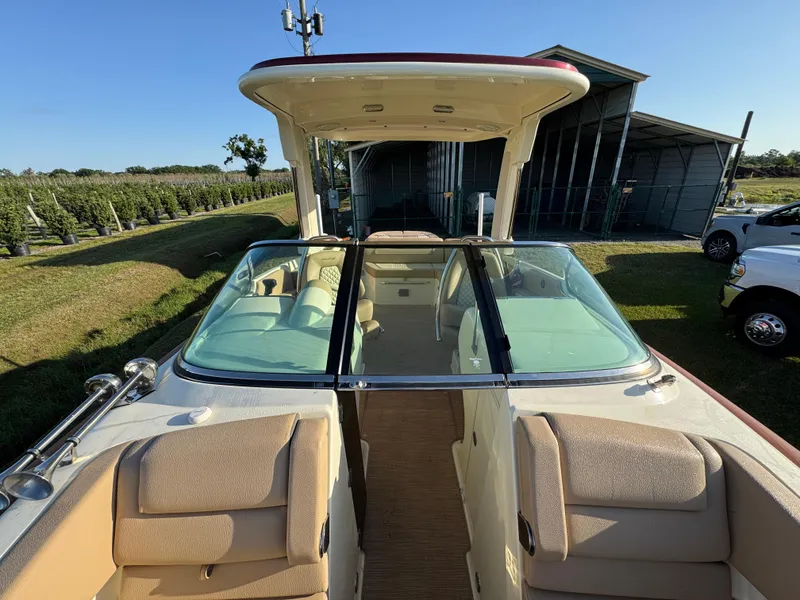 Slide: The Image of 2022 Chris-Craft Launch 25 GT boat with beige seating and glass windshield, parked outdoors. - 20