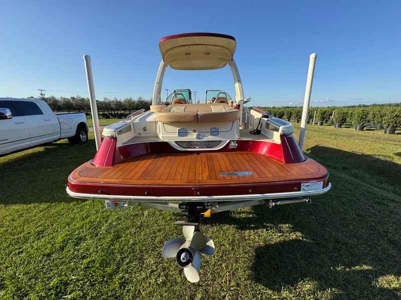 Slide: The Image of 2022 Chris-Craft Launch 25 GT boat with wooden deck, parked on grass. - 4