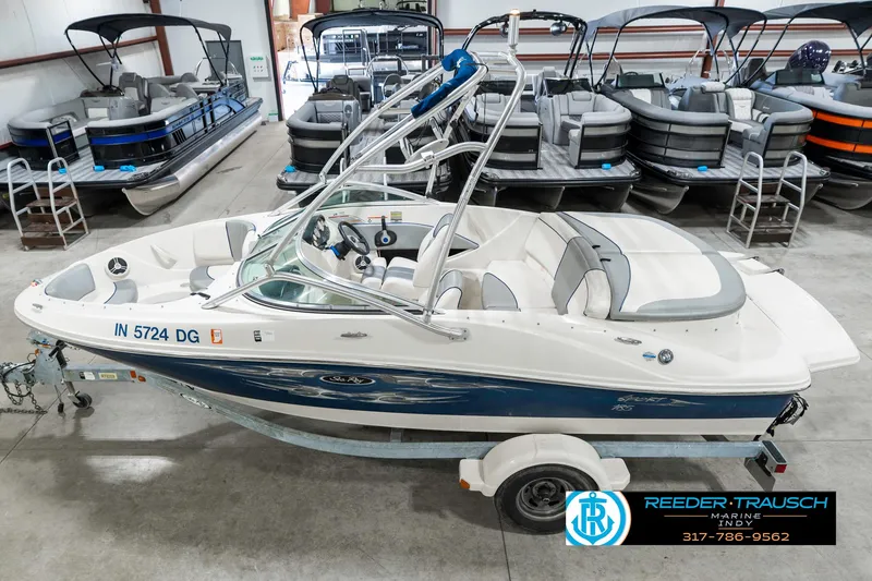 Slide: The Image of 2008 Sea Ray 185 Sport boat on trailer in showroom with other boats. - 1