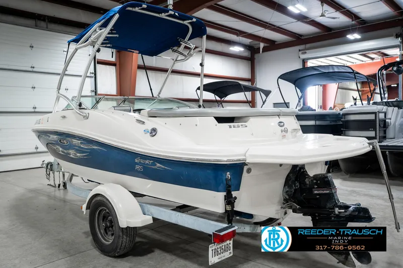Slide: The Image of 2008 Sea Ray 185 Sport boat in a showroom, featuring a blue and white design. - 10