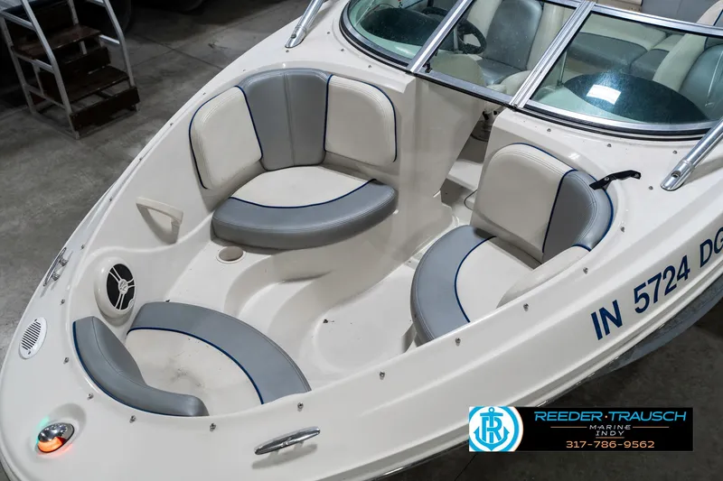 Slide: The Image of 2008 Sea Ray 185 Sport boat interior with gray and white seating, docked indoors. - 12