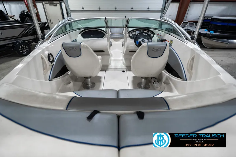 Slide: The Image of 2008 Sea Ray 185 Sport boat interior with dual seats and steering wheel in showroom. - 16