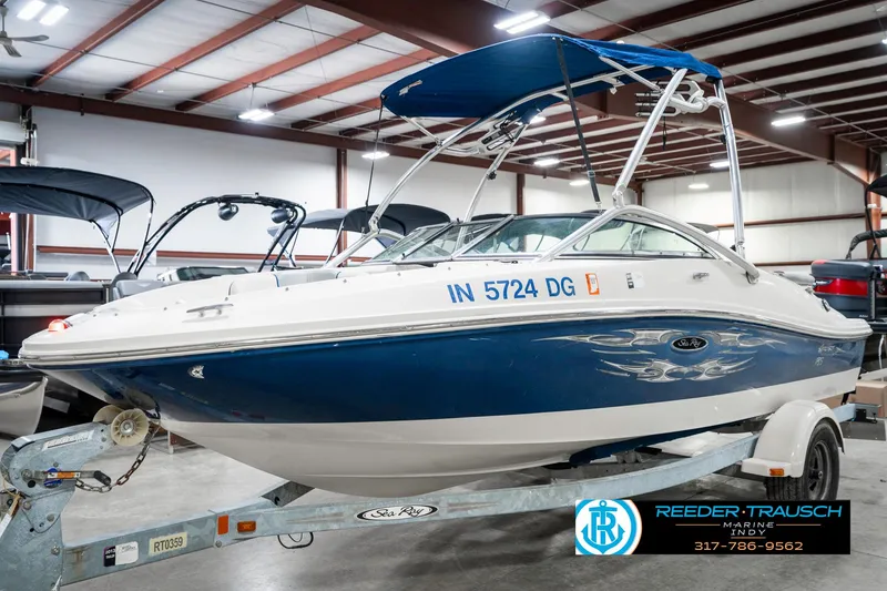 Slide: The Image of 2008 Sea Ray 185 Sport boat with blue hull on trailer in indoor showroom. - 3
