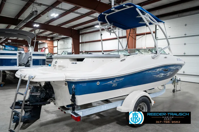 Slide: The Image of 2008 Sea Ray 185 Sport boat with blue and white design in indoor showroom. - 8