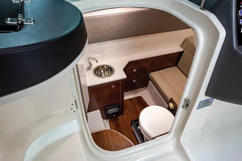 Slide: The Image of 2025 Chaparral 280 OSX cabin interior with sink, seating, and wood accents. - 13